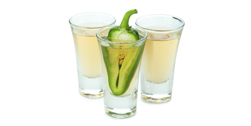 shots of tequila with pepper in one on a white background